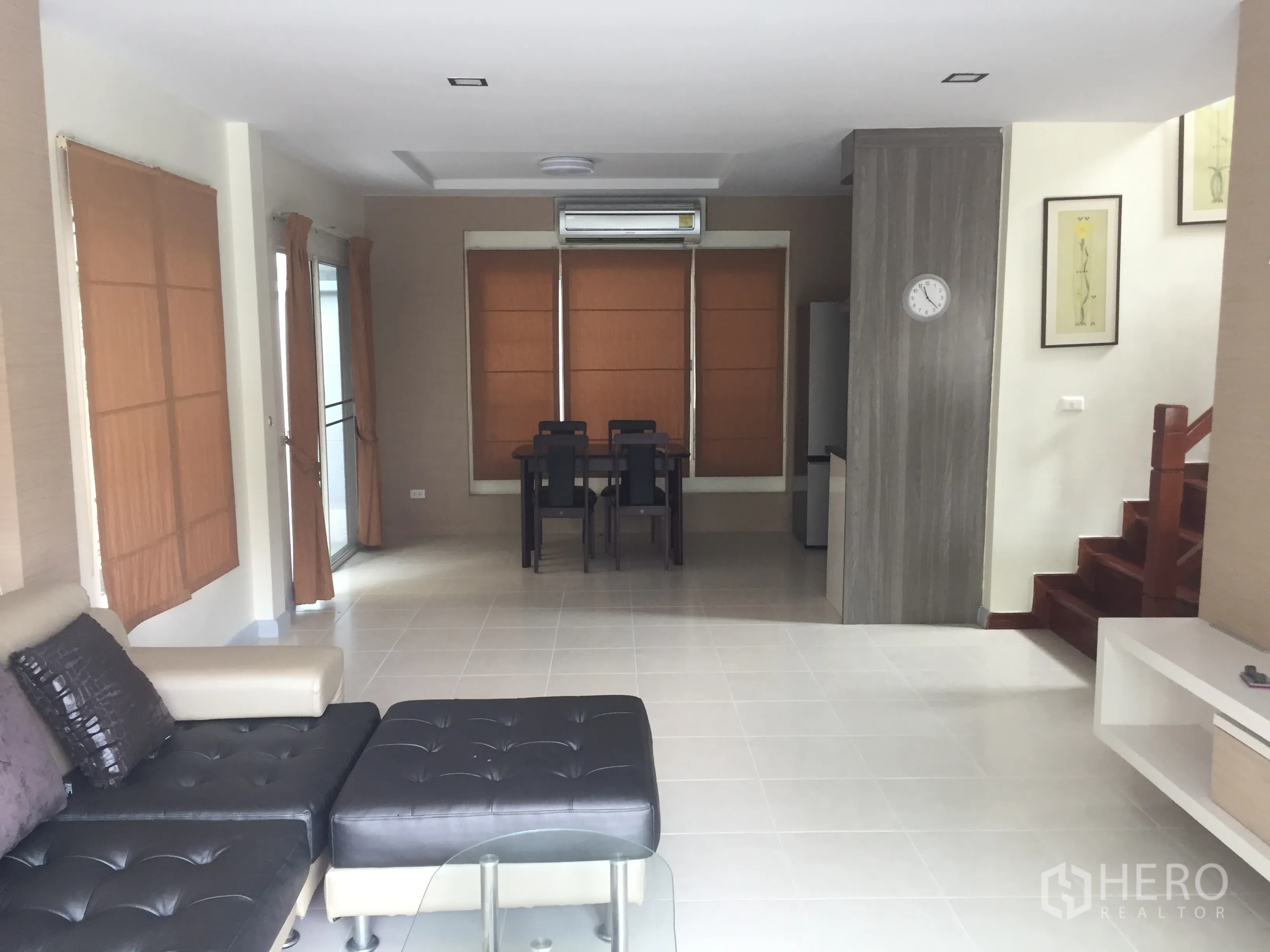 บ้าน ขายในLat Krabang, Bangkok - โถงรับแขกและรับประทานอาหารแบบโอเพ่นแปลน มีโซฟา พื้นกระเบื้อง แอร์ และบันได