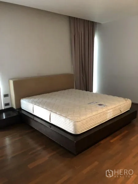 Detached House for rent in Chatuchak, Bangkok - Bedroom with platform bed, wooden flooring and full-height curtains.