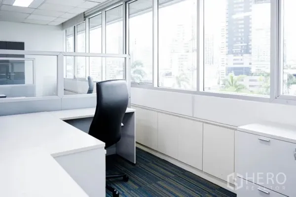 Office Space for rent in Watthana, Bangkok - Work desk by large windows with skyline views and natural light.
