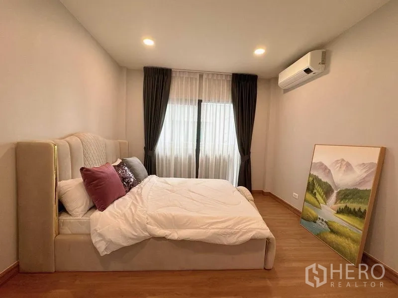 Detached House for rent or sale - Cozy bedroom with upholstered bed, wood floor, blackout curtains and wall-mounted air conditioner.