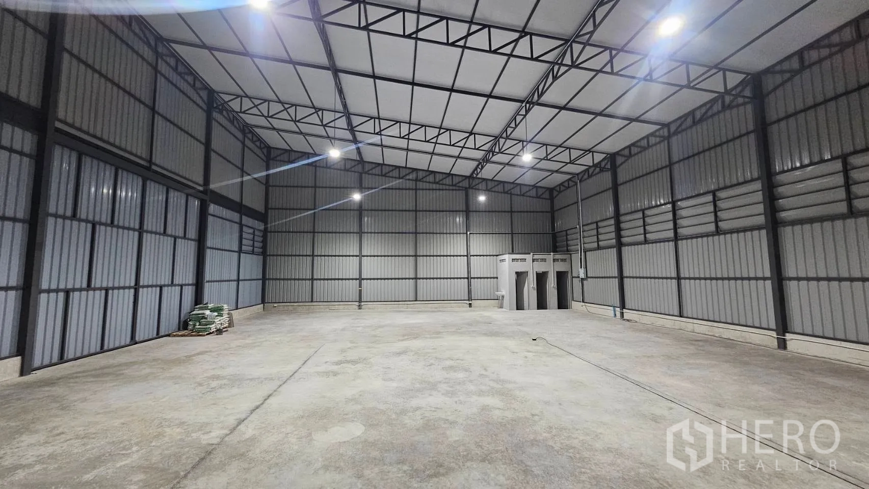 โกดัง for rent in Bang Khen, Bangkok - พื้นโกดังเปิดโล่ง พื้นคอนกรีต ไฟแขวนสูง และห้องน้ำหลายห้องด้านหลัง