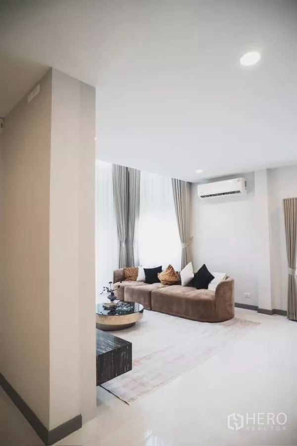 Detached House for rent in Bang Phli, Samut Prakan - Cozy lounge corner with large windows, taupe sofa, air conditioning and soft drapes.