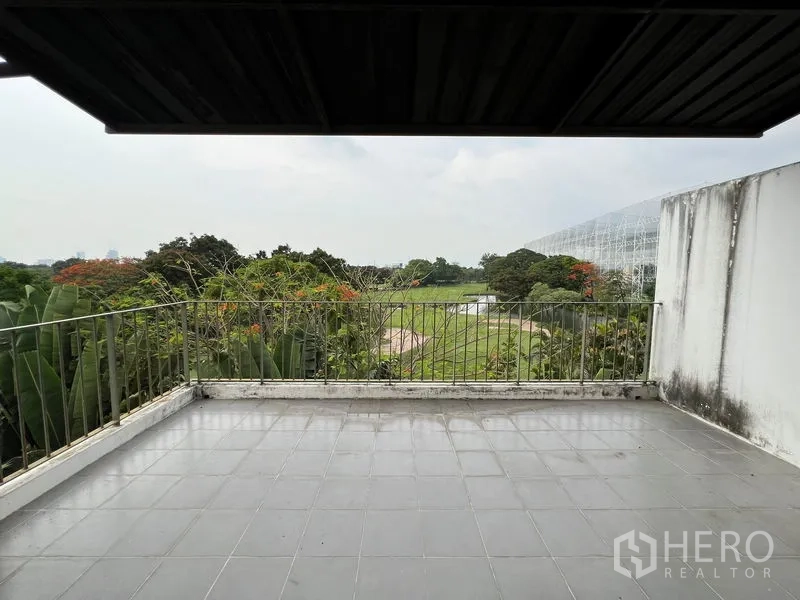 Townhouse for rent in Bang Kapi, Bangkok - Rooftop terrace with tiled floor and open green views.