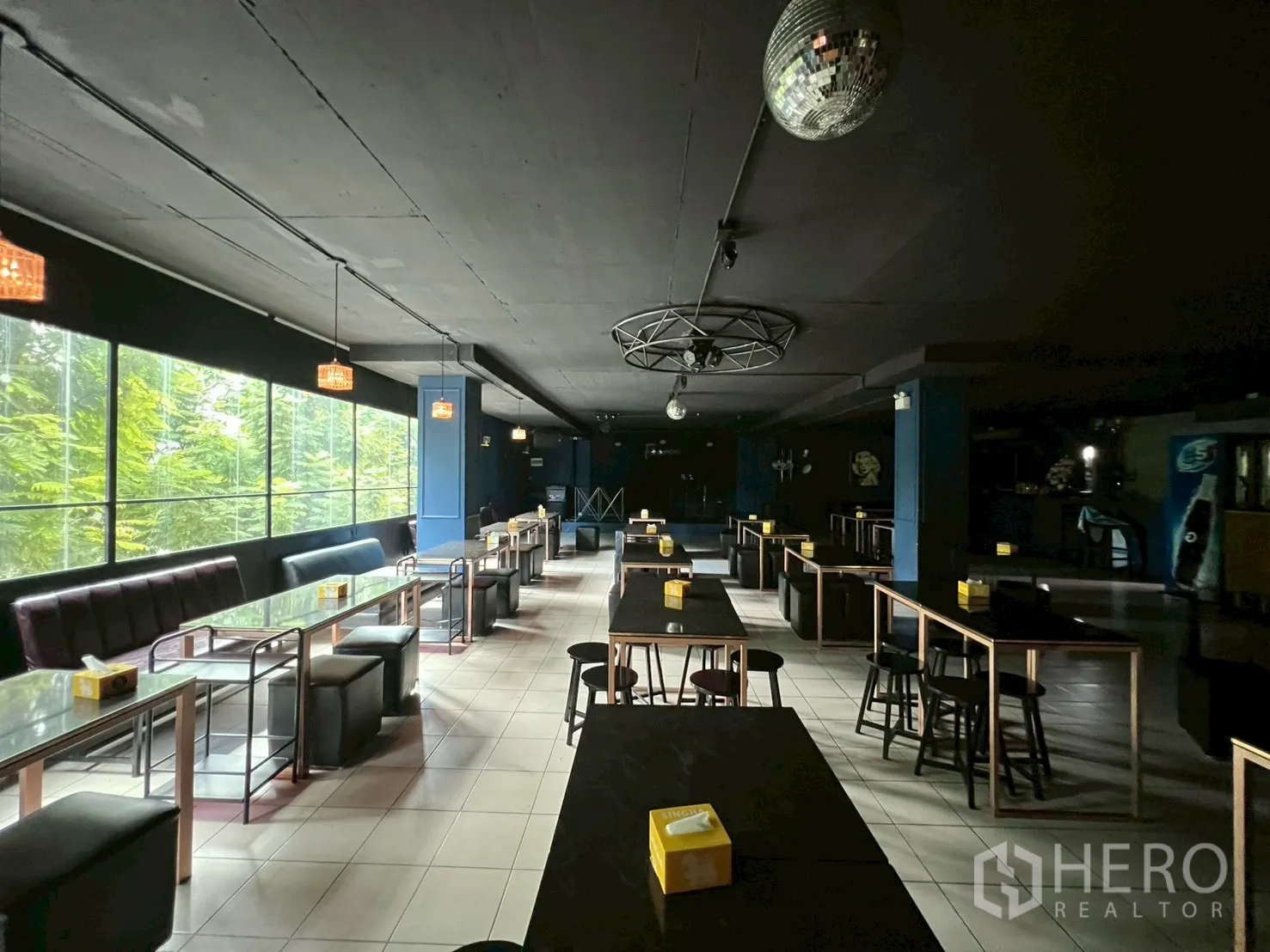 Shophouse for rent - Bar dining hall with rows of tables beside long window.