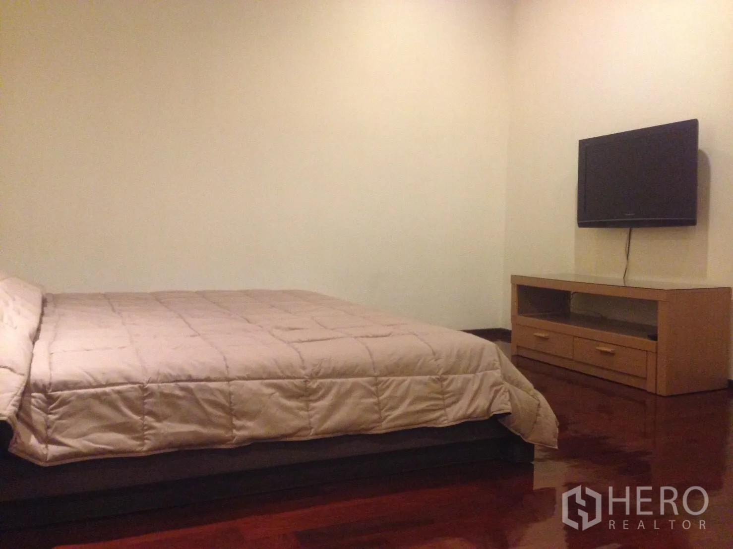 คอนโด ให้เช่าในWatthana, Bangkok - ห้องนอนพร้อมเตียงขนาดใหญ่ ทีวีติดผนัง และตู้วางทีวีไม้บนพื้นไม้มันวาว