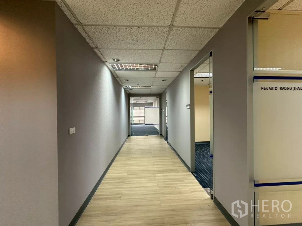 Office Space for rent in Watthana, Bangkok - Corridor connecting glass‑door offices with a city view at the end.