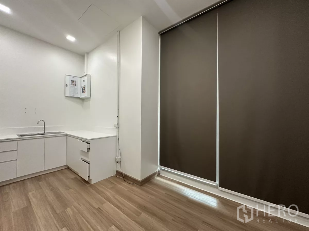 零售空间 出租在Phra Khanong, Bangkok - 小型准备间，白色橱柜与水槽，木地板与整面卷帘。