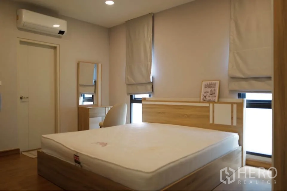บ้านเดี่ยว for rent or sale in Bang Phli, Samut Prakan - ห้องนอนเฟอร์นิเจอร์ไม้พร้อมเตียง โต๊ะเครื่องแป้ง และเครื่องปรับอากาศติดผนัง