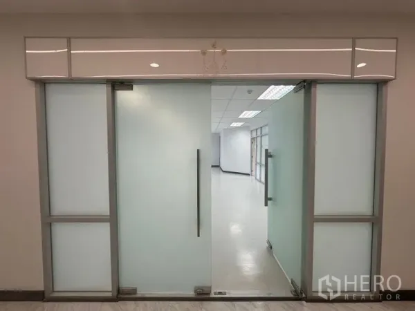 办公空间 出租在Bang Rak, Bangkok - 办公区入口的磨砂玻璃门，金属把手通往工作区。