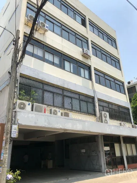 Warehouse for rent in Chatuchak, Bangkok - Multi‑storey warehouse-office facade with large windows and exterior AC units in Chatuchak, Bangkok.