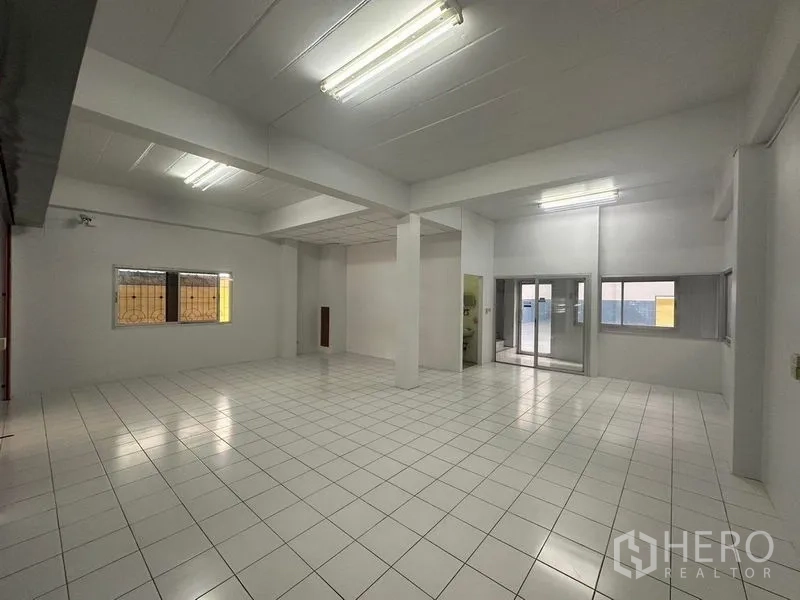 工厂 出租在Pathum Thani - 开放式白色室内，天花灯与瓷砖地面。