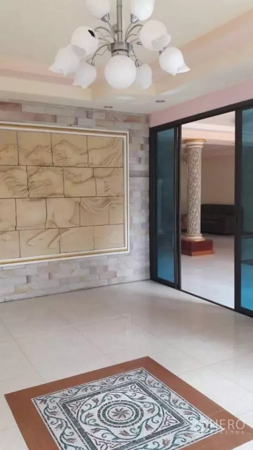 Detached House for sale in Bueng Kum, Bangkok - Family room with feature wall, sliding glass doors and chandelier.