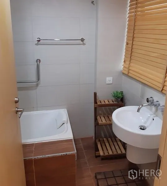 คอนโด ให้เช่าในKhlong Toei, Bangkok - ห้องน้ำมีอ่างอาบน้ำ อ่างล้างหน้าขาตั้ง ชั้นวางไม้ และมู่ลี่หน้าต่าง