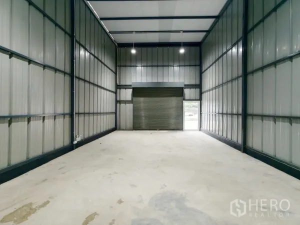 Warehouse for rent in Phra Khanong, Bangkok - Long warehouse nave with insulated roof, LED lighting, and a large shutter door.