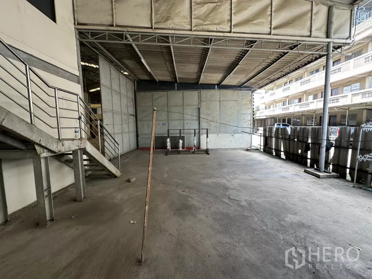 Warehouse for rent in Suan Luang, Bangkok - Covered loading area with large sliding doors and external staircase beside the warehouse.