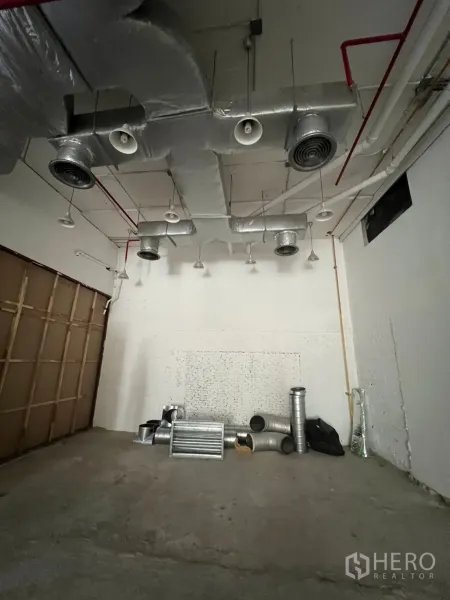 พื้นที่ขายปลีก ให้เช่า - โซนด้านหลังมีท่อดักท์ ระบบสปริงเกลอร์ และชิ้นส่วนงานระบบวางเตรียมติดตั้งบนพื้น
