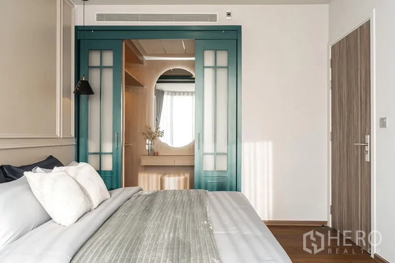 คอนโด ให้เช่าในKhlong Toei, Bangkok - ห้องนอนสว่าง เตียงคิงส์ ประตูสีเขียว และผนังบัวสไตล์คลาสสิก