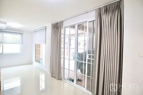 Home Office for rent in Bang Sue, Bangkok - Bright ground-floor room with sliding glass doors, full-length curtains and glossy tile flooring.