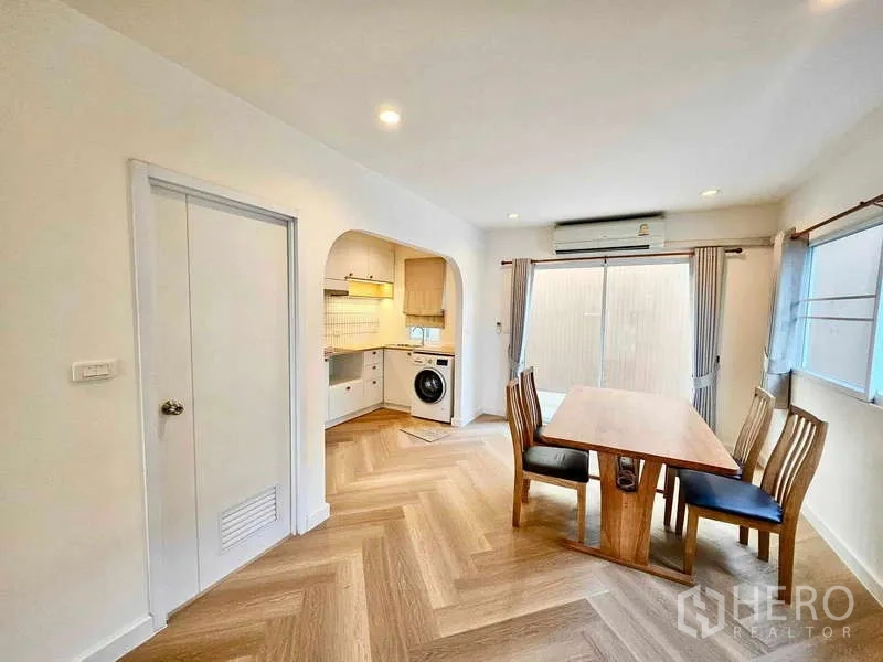 ทาวน์เฮาส์ ให้เช่าในSuan Luang, Bangkok - มุมรับประทานอาหารพร้อมโต๊ะไม้ หน้าต่างและประตูกระจก ติดทางเข้าโค้งไปยังครัวบิวท์อิน