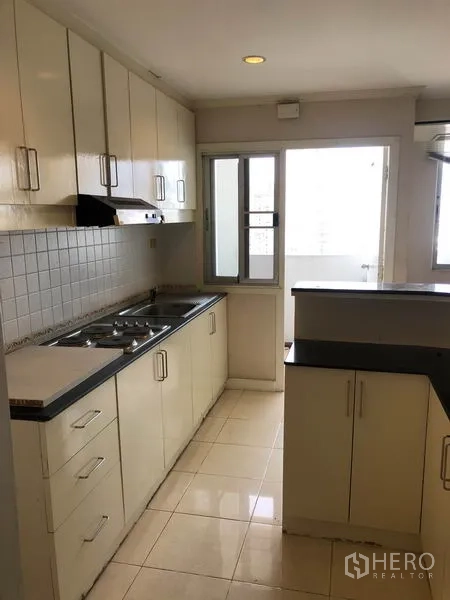 คอนโด ขายในWatthana, Bangkok - ครัวแบบแกลเลย์ เตาแก๊ส เครื่องดูดควัน ผนังกระเบื้อง และประตูออกระเบียง