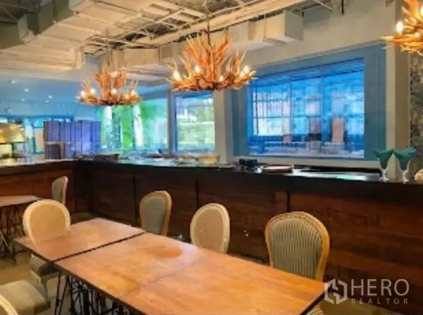 零售空间 出租在Watthana, Bangkok - 吧台近景，鹿角吊灯与大窗户