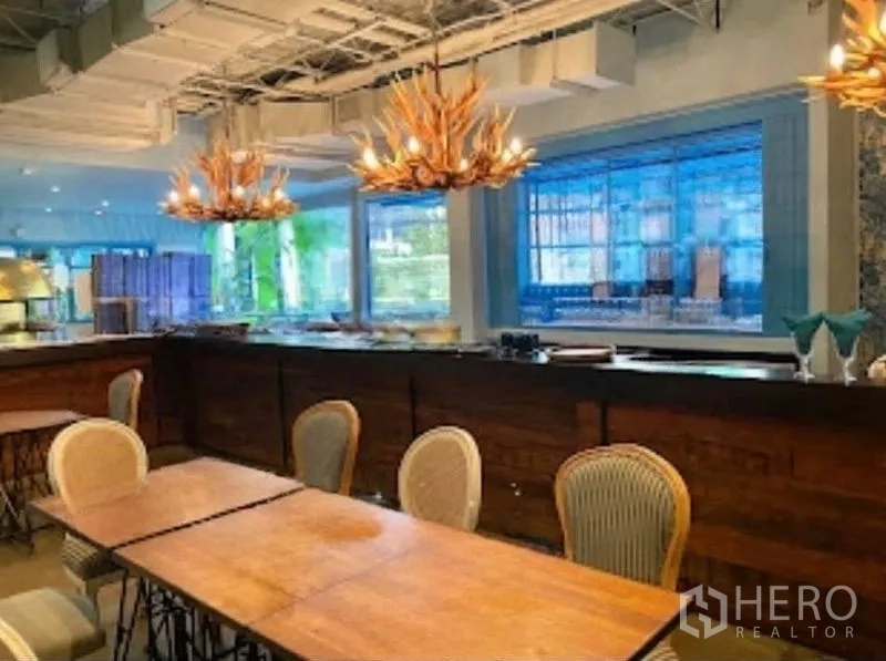 零售空间 出租在Watthana, Bangkok - 吧台近景，鹿角吊灯与大窗户