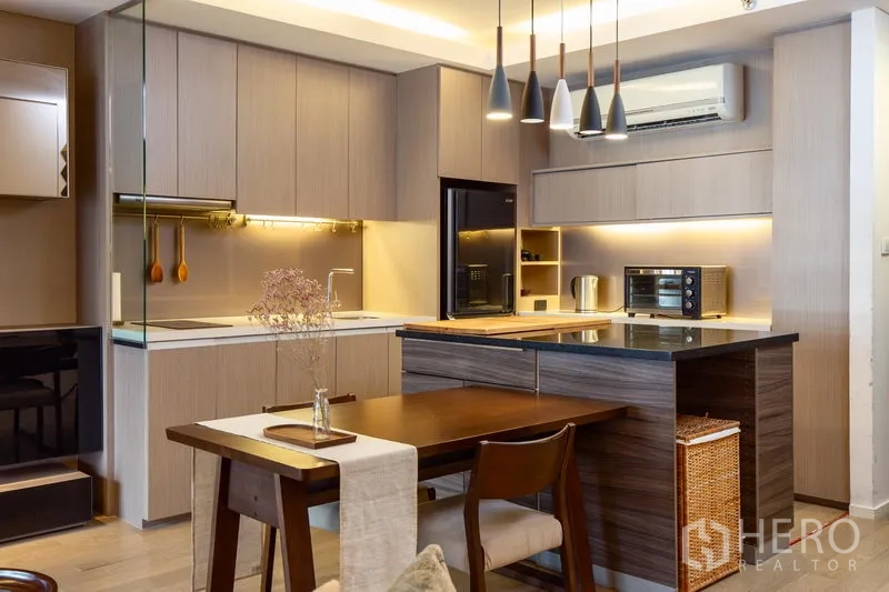 公寓 出租在Watthana, Bangkok - 现代厨房，木纹橱柜与中岛台面，吊灯与内置家电齐全。