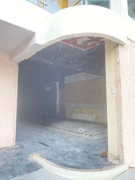 零售空间 出租在Watthana, Bangkok - 临街商铺拱形门头，内部为未完工空间，黑色顶与地砖清晰可见。