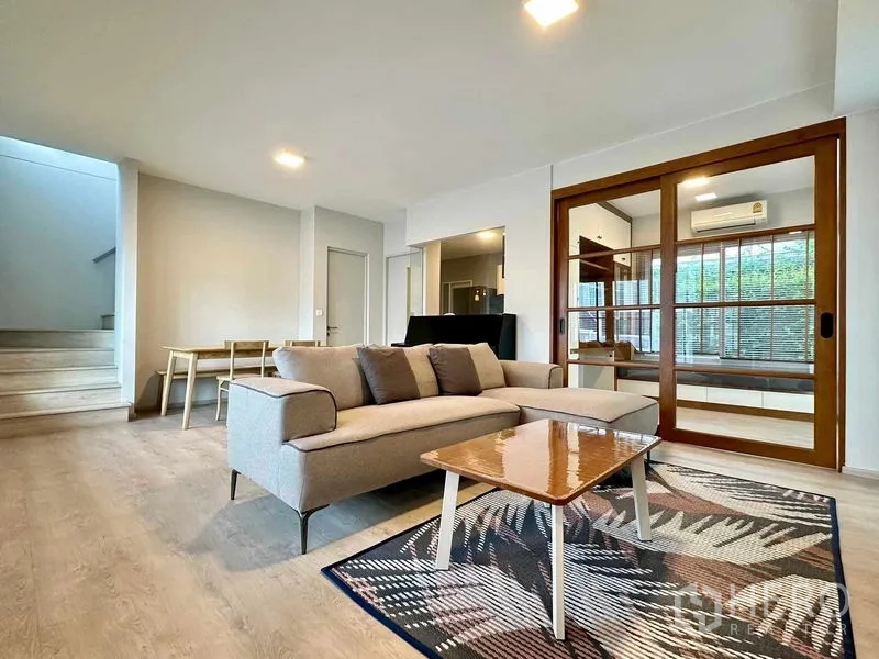 独立式住宅 出租或出售在Prawet, Bangkok - 开放式客餐厅，沙发组，推门通往书房与楼梯。