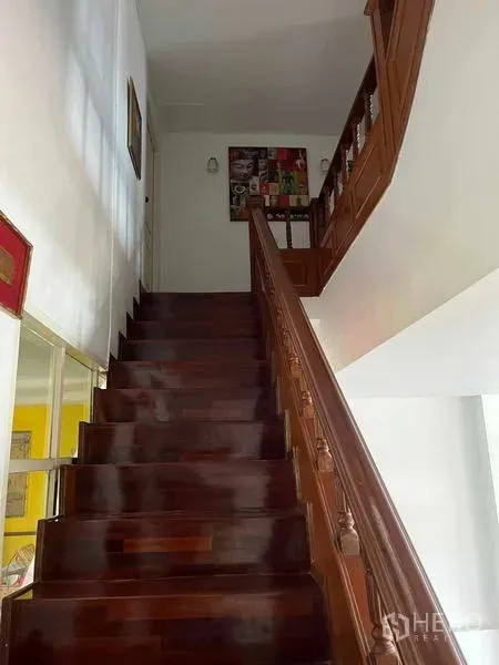 Home Office for rent in Bang Rak, Bangkok - Polished wooden staircase with carved railing leading to the upper floor.