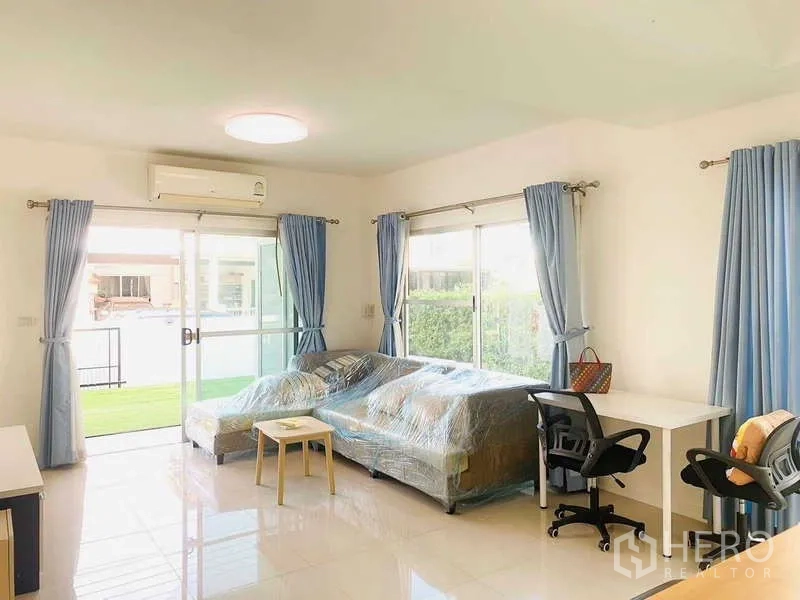 Detached House for rent or sale - Air-conditioned living room with sliding glass doors, blue curtains and sofas.
