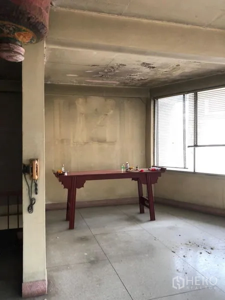 อาคารพาณิชย์ ให้เช่าในBangkok - ห้องภายในโล่ง เพดานคอนกรีต ผนังเก่า มีโต๊ะไม้และหน้าต่างบานใหญ่