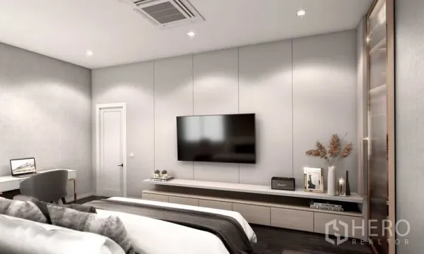 Detached House for sale in Prawet, Bangkok - Bright bedroom with wall-mounted TV, work desk and soft neutral décor.