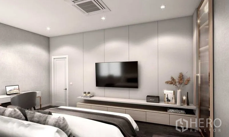 Detached House for sale in Prawet, Bangkok - Bright bedroom with wall-mounted TV, work desk and soft neutral décor.