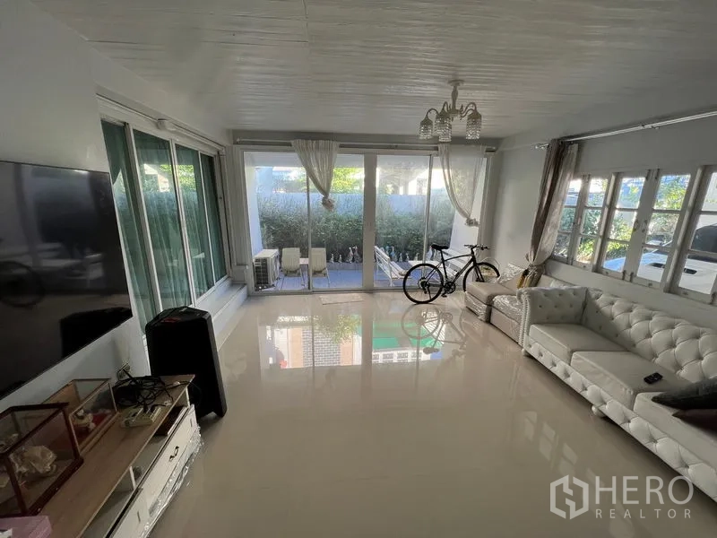 บ้าน ขายในLat Krabang, Bangkok - ห้องนั่งเล่นกว้าง โซฟาหนังสีขาว หน้าต่างบานใหญ่และประตูกระจกบานเลื่อน