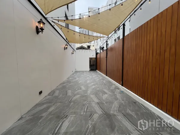 พื้นที่ขายปลีก ให้เช่า - ทางเดินกลางแจ้งยาว ติดไฟผนังสไตล์วินเทจ รั้วไม้ และผ้าใบพร้อมไฟประดับ