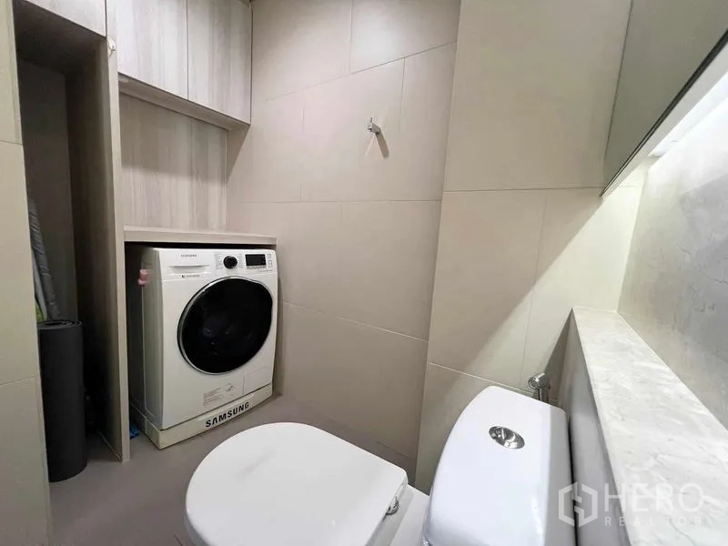 คอนโด ให้เช่าหรือขาย - ห้องน้ำที่สองพร้อมมุมวางเครื่องซักผ้า ตู้เก็บของ และโถสุขภัณฑ์