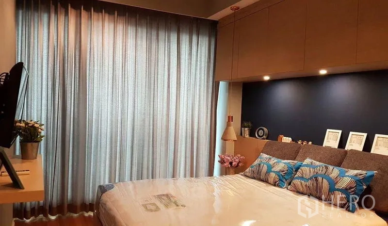 คอนโด ให้เช่าในKhlong San, Bangkok - ห้องนอนผ้าม่านเต็มความสูง ผนังสีน้ำเงินและโคมไฟแขวนข้างเตียง