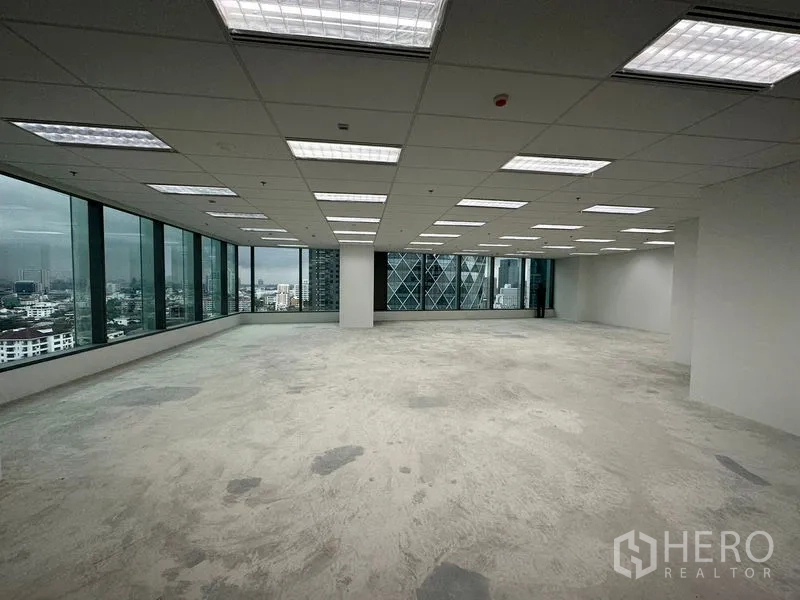 办公空间 出租在Ratchathewi, Bangkok - 宽敞角位工作区，网格吊顶与荧光灯照明，享拉差贴威天际线景观。