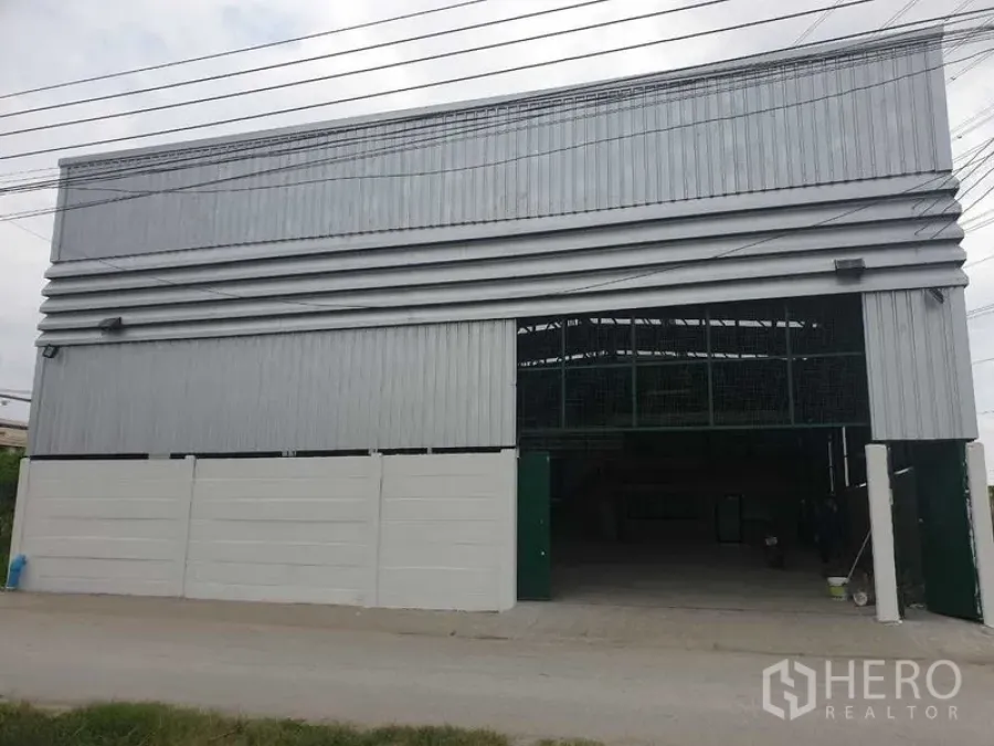 Warehouse for rent in Prawet, Bangkok - Open warehouse entrance showing tall clearance and corrugated metal facade.