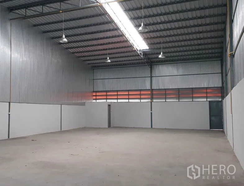 货栈 出租在Mueang Pathum Thani, Pathum Thani - 仓库内部高挑空间，金属墙面与天窗灯带，平整混凝土地面，位于巴吞他尼。