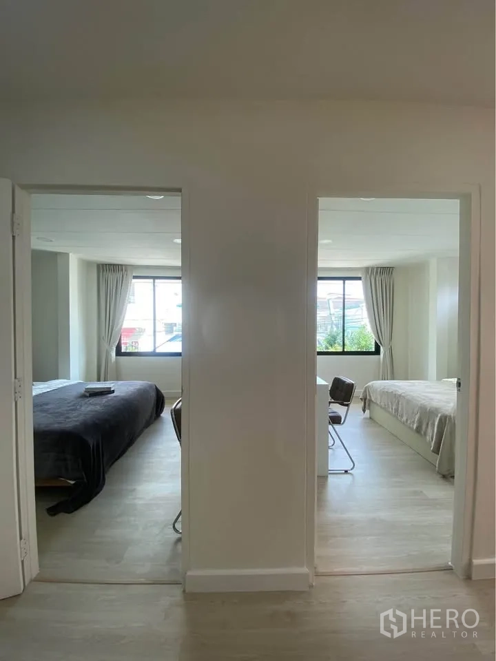 独栋房屋 for rent in Huai Khwang, Bangkok - 走廊望向两间相邻卧室，可见大窗与书桌。