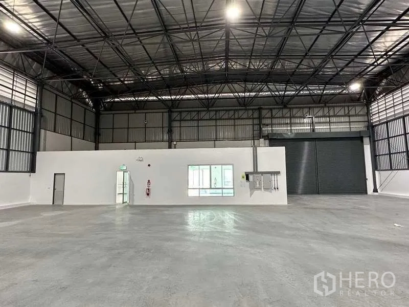 โรงงาน ให้เช่าในBang Sao Thong, Samut Prakan - ภายในโกดังโปร่งสูง โครงหลังคาเหล็ก พื้นคอนกรีตขัดมัน และประตูม้วน