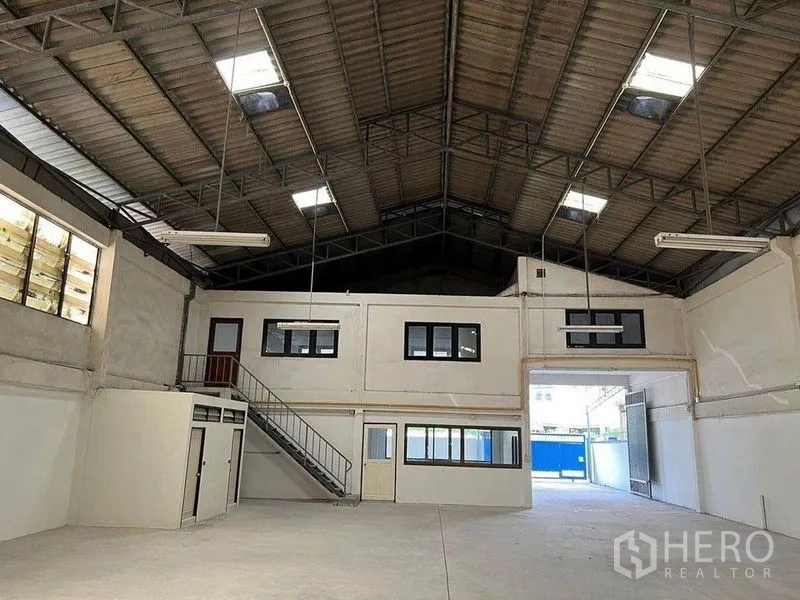 Warehouse for rent in Khlong Toei, Bangkok - Warehouse interior with mezzanine office, staircase, and wide entry opening.