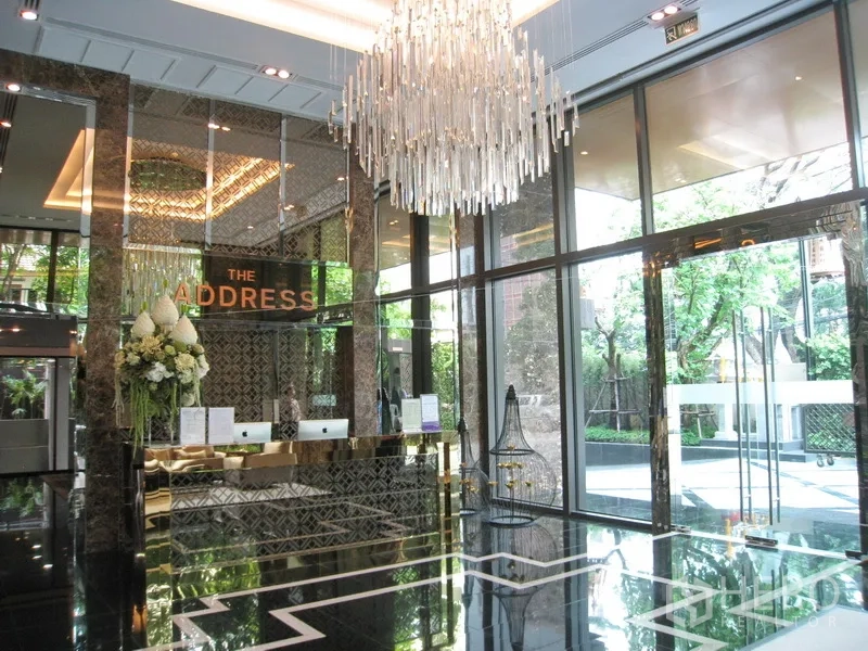 Condominium for rent in Watthana, Bangkok - Grand lobby with a crystal chandelier, mirrored walls, and reception desk.