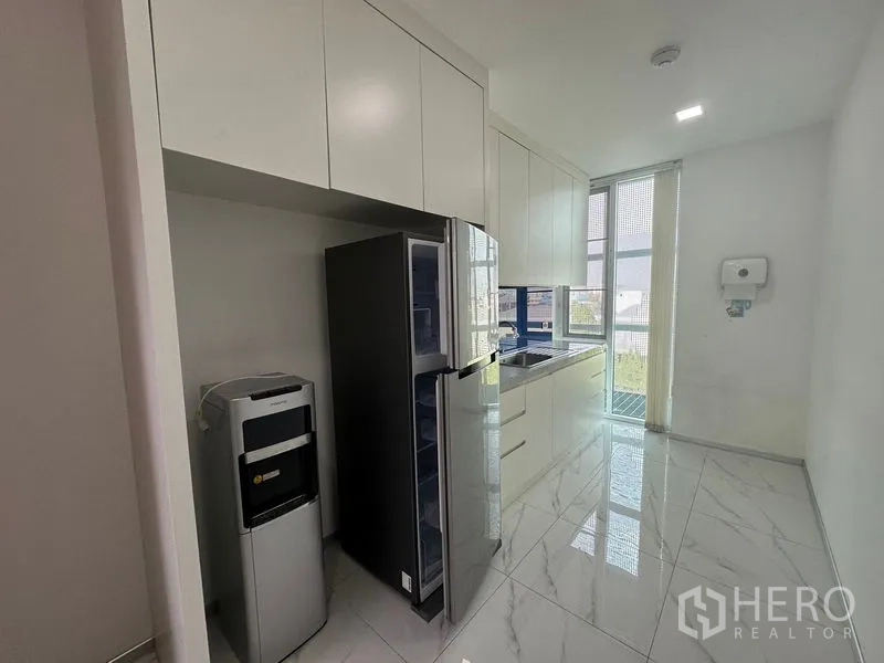 Office Space for rent - Symmetrical view across open workstations with blue screens beneath LED ceiling panels.