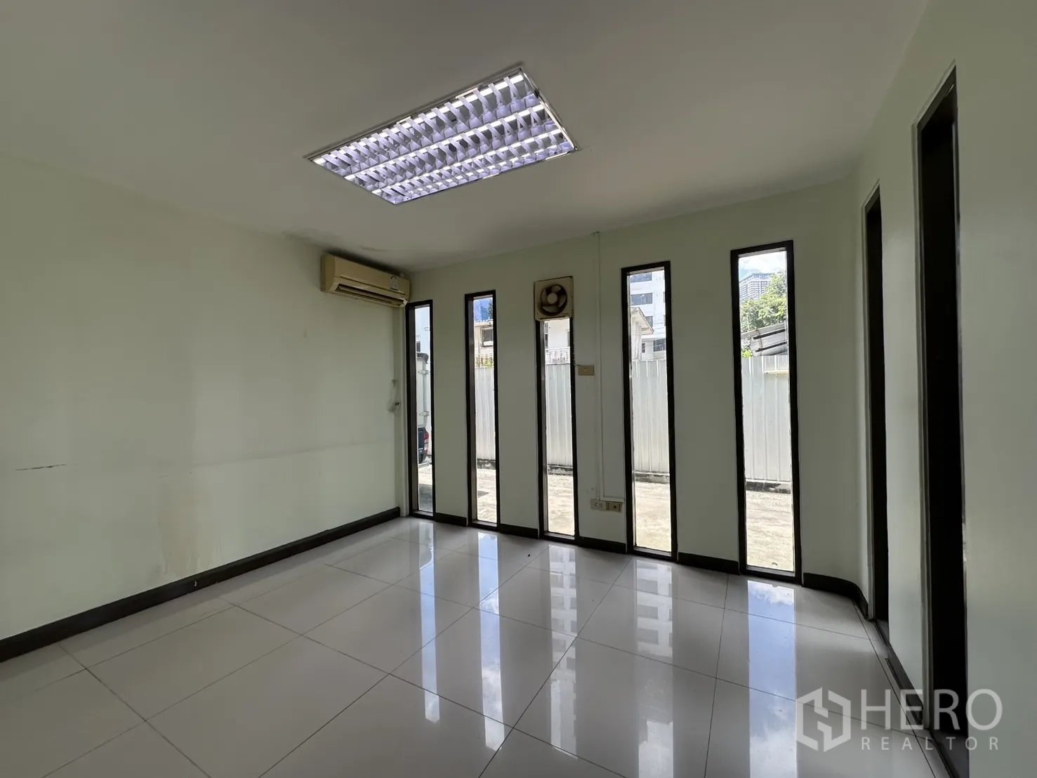 零售空间 出租在Watthana, Bangkok - 采光明亮的房间，落地窄窗与墙挂空调。