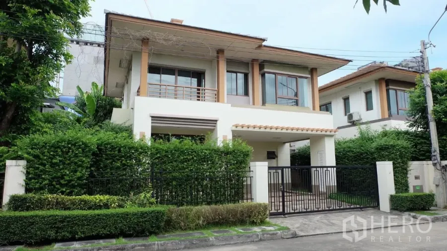 บ้าน ขายในBang Phli, Samut Prakan - บ้านเดี่ยวสองชั้น หน้าบ้านรั้วเหล็ก ระเบียง และแนวไม้พุ่มเขียวชอุ่ม