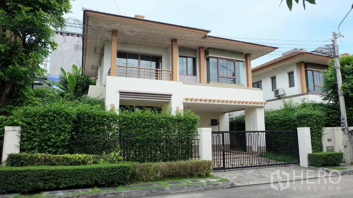 บ้าน ขายในBang Phli, Samut Prakan - บ้านเดี่ยวสองชั้น หน้าบ้านรั้วเหล็ก ระเบียง และแนวไม้พุ่มเขียวชอุ่ม