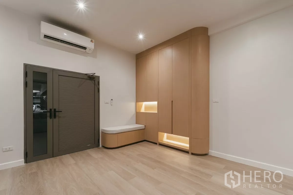 联排别墅 出租在Watthana, Bangkok - 入口房间，带定制储物柜、换鞋长椅与木地板。